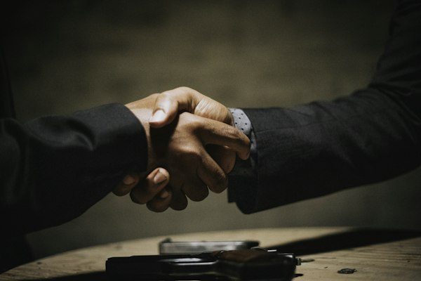 Two executives shaking hands building trust